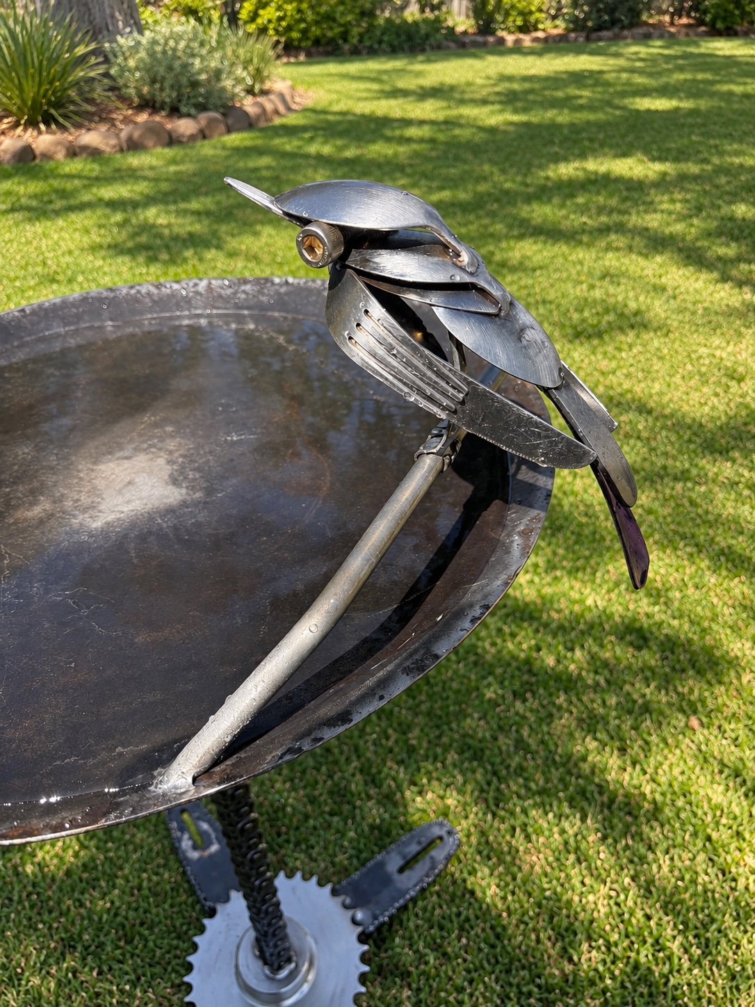 Close-up of the handmade metal bird perched on the bath
